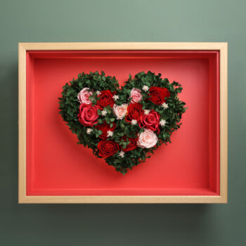 Corazón de flores preservadas en marco de madera, vista frontal iluminacion diurna