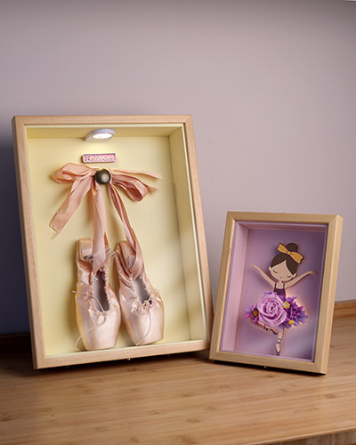 Cuadro de puntas de ballet junto a bailarina con flores preservadas